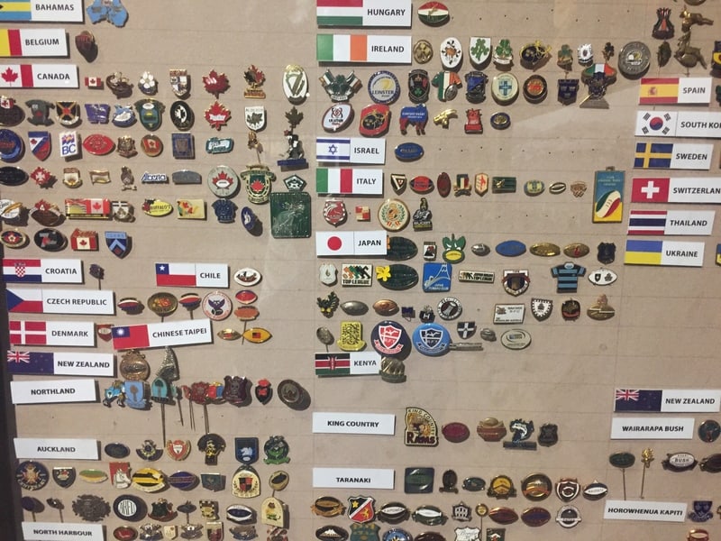 a board full of pins or what some call broaches from around the world