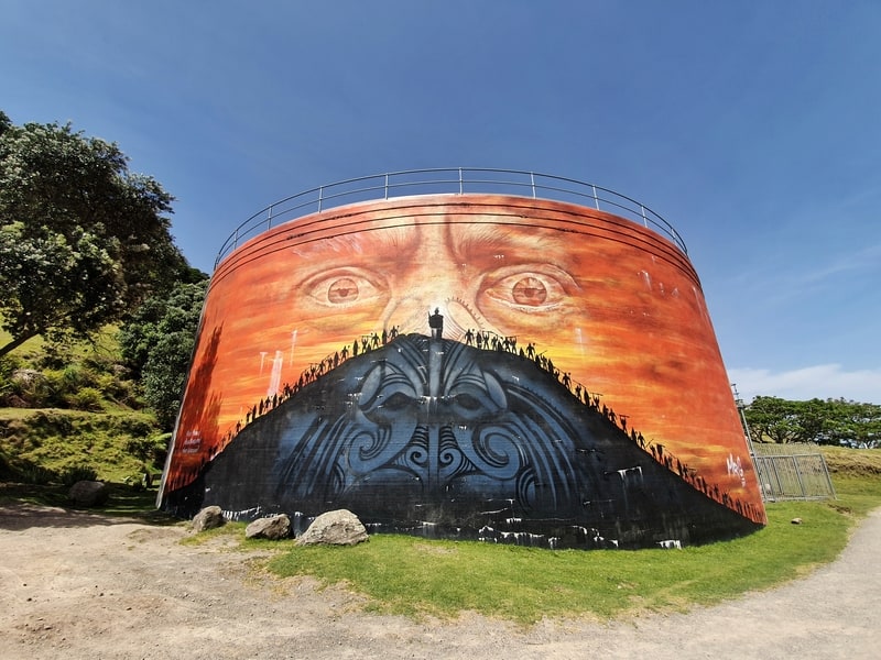 street art of a maori face on a water tank