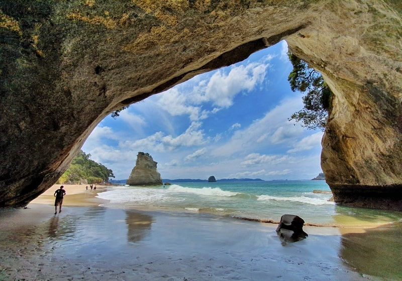 a photo from under a rock archway at cathedral cove