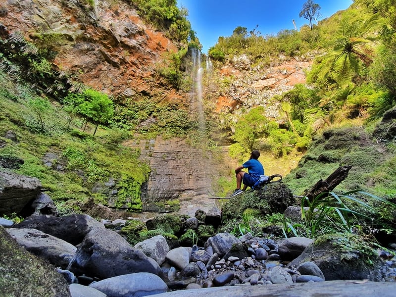 man looking at the waterfall