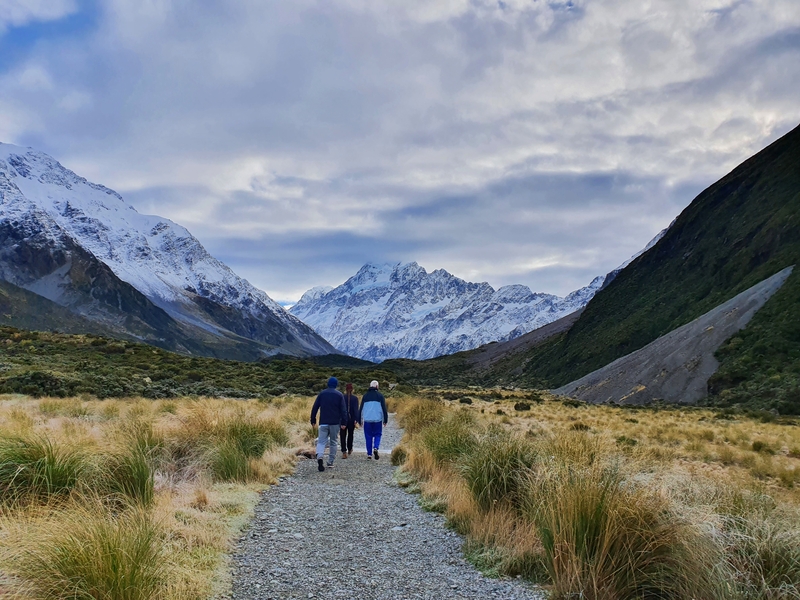 people walking on the hooker valley track with mount cook in the distance