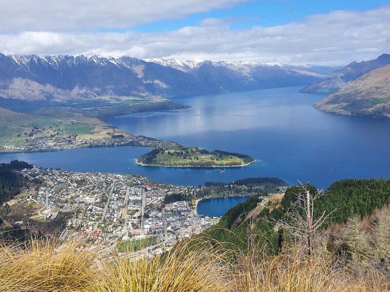 a shot from a peak above queenstown where you can see the town, lake and remarkables