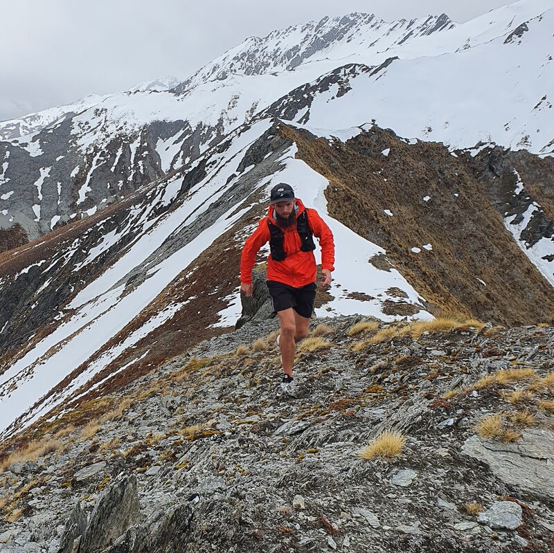 man wearing macpac tempo trail running jacket in mountains