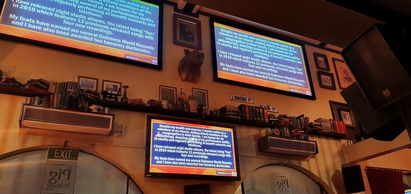 three tvs with text hanging on a white wall that has a mantlepiece