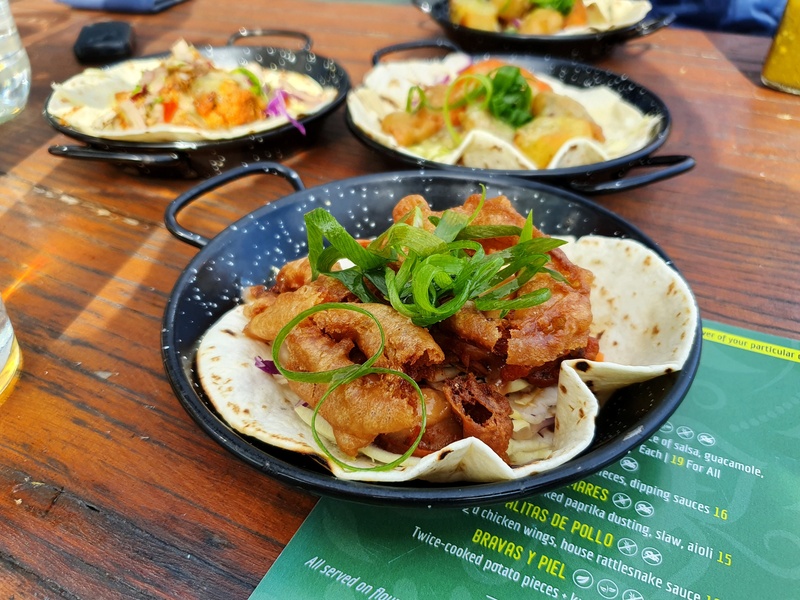 three tacos in mini black bowls with various toppings at amigos wanaka