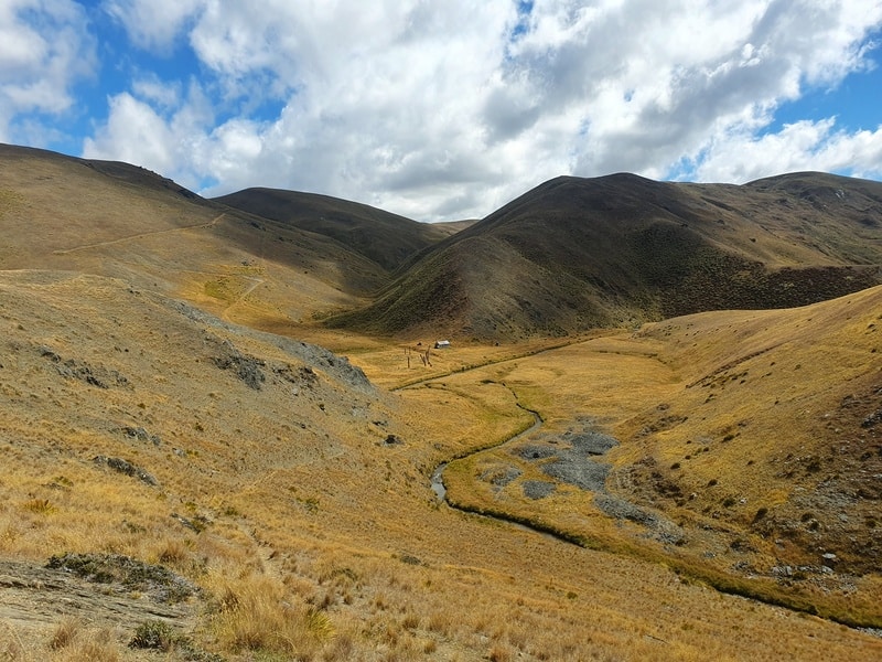 view of meg hut in the valley from the cardrona cromwell packtrack