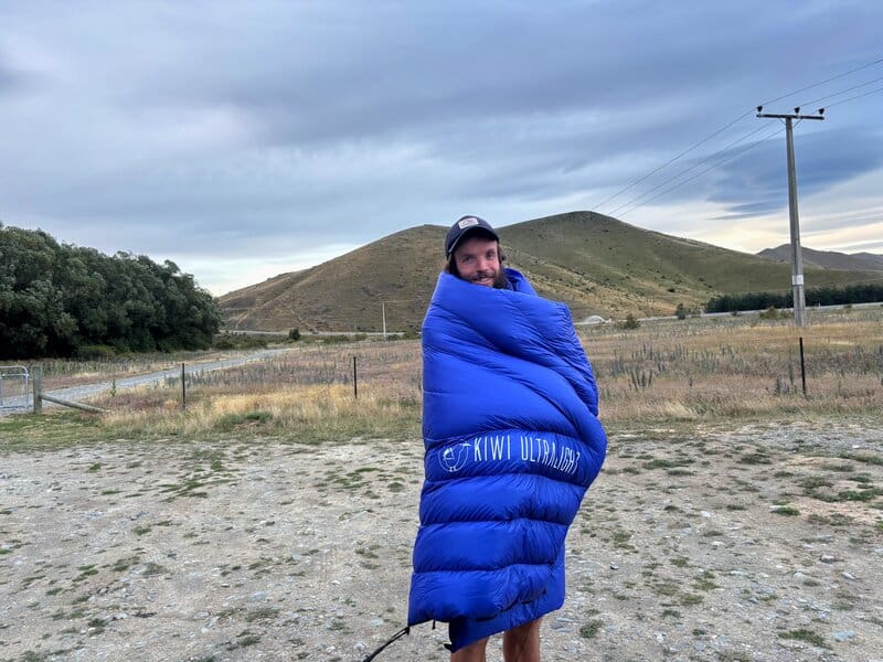 man standing with kiwi ultralight quilt